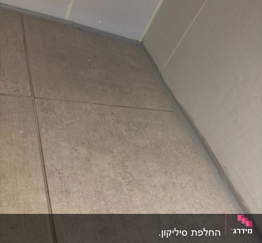 איטום ויישום סיליקון אפור בחיבור בין רצפת אריחים לקיר